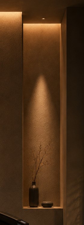 壁の窪みに置かれた一輪挿しと、上から落ちる細い光。